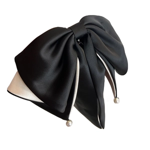 Elegant black satin bow hair clip with white contrast trim and hanging pearl charms