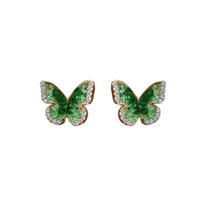 Gold plated butterfly earrings with green stones and sparkling zircon stones on white background