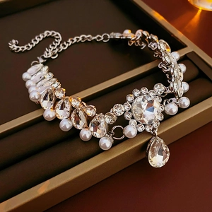 Detail of flower necklace with sparkling crystals and teardrop pearl pendant on a tray