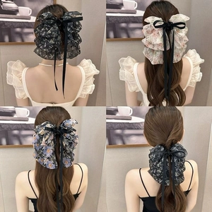 Detail view showing four styles of elegant floral bow hair clips with long ribbons.