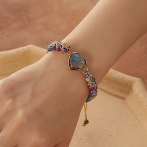 Detail of handmade woven double-layer stone bracelet with heart pendant on model wrist
