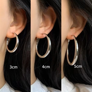 Visual comparison of 3cm, 4cm, and 5cm silver hoop earrings on ears for size perspective