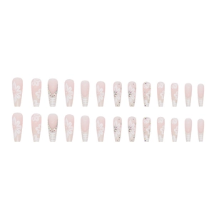 Long coffin press-on nails with pink base, white floral patterns, and small rhinestones