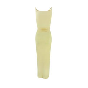Close-up of elegant light yellow maxi dress with shirred waist and side slit details