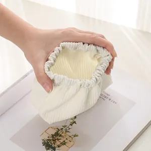 Minimalist cream corduroy coin pouch with squeeze closure for small items