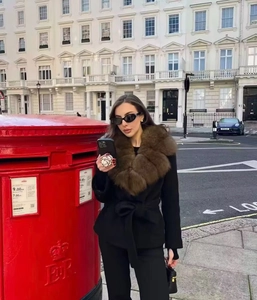 Chic women's black belted jacket featuring a plush oversized brown faux fur collar