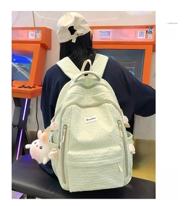 Détail du sac à dos vert menthe en tissu gaufré avec un porte-clés lapin blanc