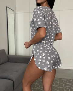 Detail of grey short sleeve loungewear set featuring white paw prints and elastic waist
