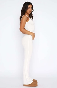 Detailed view of the white ribbed knit fabric texture and side silhouette of the jumpsuit