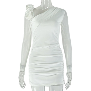 Detail of white one-shoulder dress featuring 3D floral accent and ruched slimming fabric