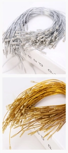 Close-up of gold and silver tag fasteners with bullet head locking mechanism for labels.