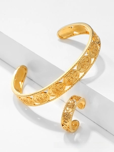 Detailed view of gold plated hollow leaf pattern on open bangle and ring jewelry set