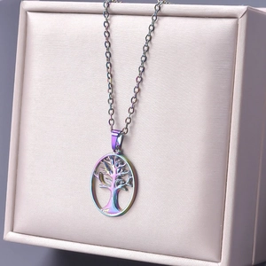 Iridescent tree of life pendant necklace displayed on a beige jewelry gift box