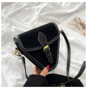 Detalle del bolso de silla de gamuza negra con costuras blancas y hebilla dorada