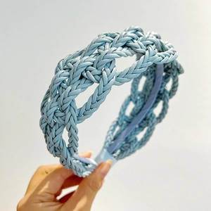 Detailed view of light blue braided faux leather headband with intricate weave texture