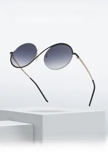Detail of semi-rimless sunglasses featuring a unique gold cross bridge and gradient lenses