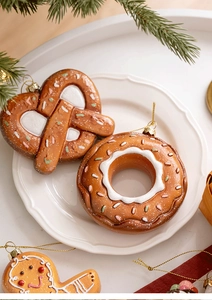 Close-up of gingerbread style Christmas ornaments with colorful sprinkles on a ceramic plate