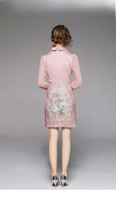 Detail of pink satin dress featuring exquisite floral embroidery and elegant wave collar