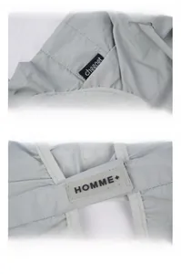 Detail view of the waterproof dog jumpsuit featuring brand tags and nylon fabric texture