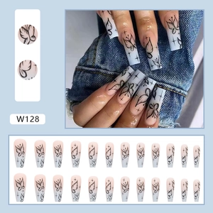Long coffin press on nails featuring nude gradient finish and black butterfly patterns