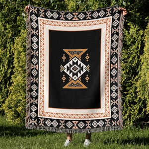 Detail of bohemian knit blanket with Aztec geometric patterns and woven tassels