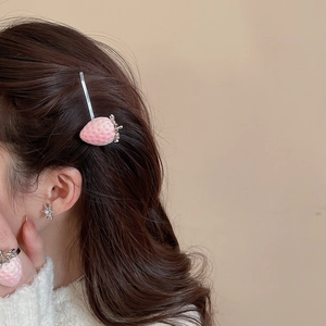 Detailed close-up of pink flocked strawberry necklace and earring jewelry set on model