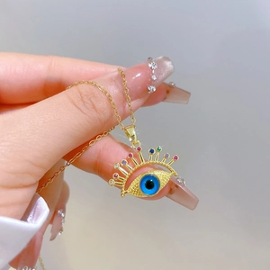 Detail of gold evil eye necklace with colorful crystals and blue eye center piece