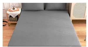 Deep grey fitted sheet and pillowcases shown in a cozy bedroom setting with natural light