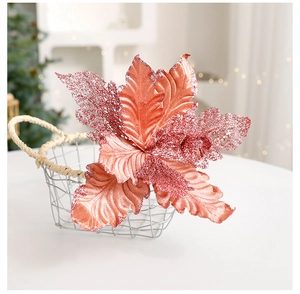 Detail of rose gold poinsettia with glitter hollow leaves in a white decorative basket