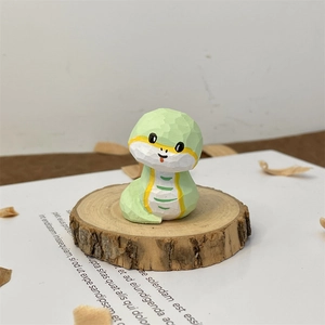 Detail of hand-carved green wooden snake figurine with manual cutting texture on wood base