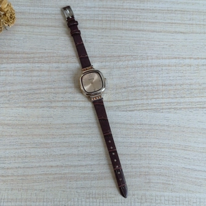 Elegant square gold watch with dark brown leather strap and rhinestone dial markers