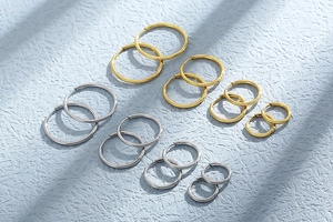 Macro view of assorted gold and silver stainless steel hoop earrings in various sizes