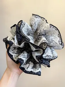 Gros plan d'un chouchou floral avec bordure en dentelle et imprimé noir et blanc élégant