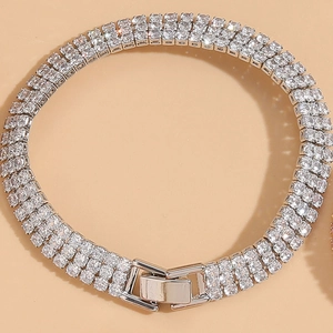 Detailed close-up of a silver triple-row zircon tennis bracelet with a secure metal clasp