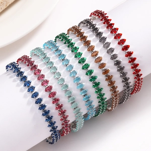 Primo piano di bracciali tennis in zircone di vari colori su un supporto espositivo.