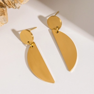 Detail of matte gold geometric crescent earrings with high-quality brushed metal texture