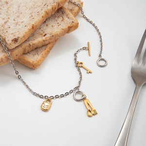 Vue détaillée du collier à fermoir OT avec breloques clé dorée et cadenas en forme de cœur