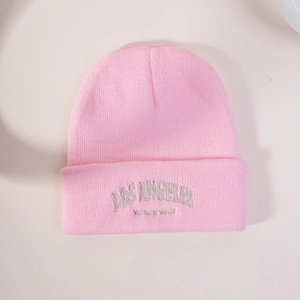 Gros plan sur le bonnet en maille rose avec broderie de lettres LOS ANGELES blanches