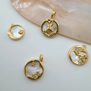 Detail of 18K gold plated charms with natural mother of pearl moon and rabbit designs