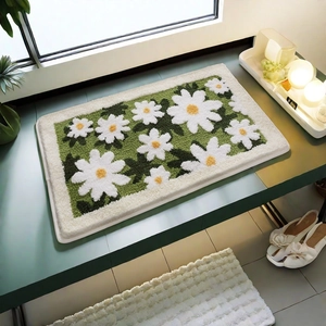Detailed close-up of 3D floral bath mat with plush green and white daisy tufting