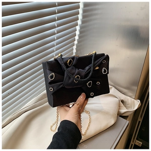Elegant black velvet evening clutch with bow detail and shimmering gold rhinestones