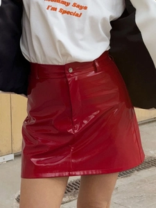 Detailed texture of red high-waist faux leather mini skirt in a street fashion style