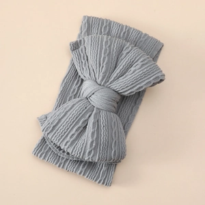 Detailed view of gray cable-knit texture on a soft oversized baby bow headband