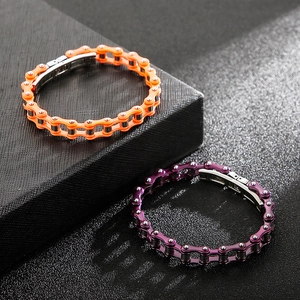 Close-up of industrial bicycle chain bracelets in orange and purple metallic finishes