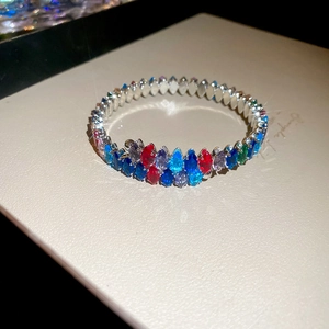 Makroaufnahme von Silberarmband mit bunten Zirkoniasteinen im Marquise-Schliff in Wellenform