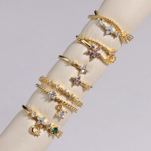 Gros plan de bagues dorées avec zircons colorés sur des présentoirs à bijoux
