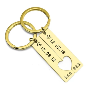 Macro shot of custom engraved gold rectangle keychains with a heart puzzle cutout