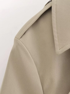 Close-up of shoulder epaulets and notched lapel on khaki twill trench coat jacket