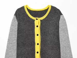 Detailed view of the fine knit texture and vibrant yellow ribbed edges on the cardigan