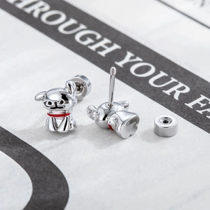 Puppy shaped titanium steel stud earrings with red collar details on newspaper background